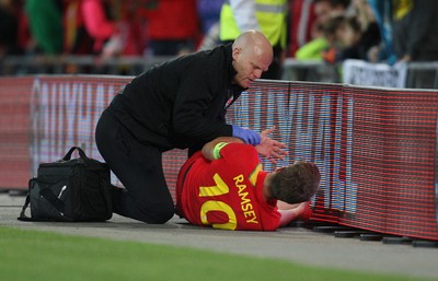 100913 - Wales v Serbia, FIFA 2014 World Cup Qualifying - Wales' Aaron Ramsey lies injured after colliding with the advertising displays- (c) Huw Evans Picture Agency, Cardiff