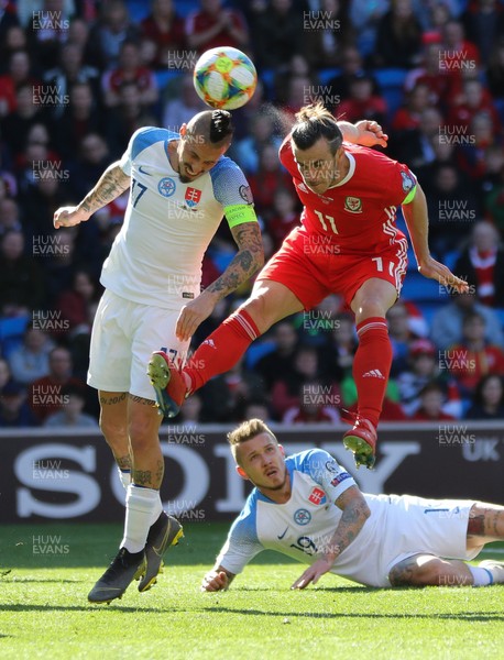 240319 - Wales v Slovakia, UEFA Euro 2020 Qualifier - Gareth Bale of Wales compete for the ball with Marek Hamsik of Slovakia as he looks to head at goal