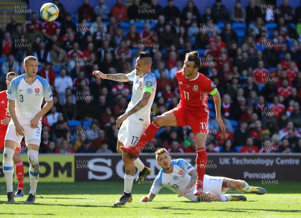 240319 - Wales v Slovakia, UEFA Euro 2020 Qualifier - Gareth Bale of Wales compete for the ball with Marek Hamsik of Slovakia as he looks to head at goal