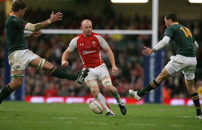 13.11.10 Wales v South Africa... Wales' Martyn Williams threads the ball between South Africa's Juan Smith(rt) and Bjorn Basson. 