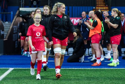190926 Wales v South Africa, Vodafone Wales WXV Series - Wales co-captain Alex Callender walks out with match mascot Lola Snowdon