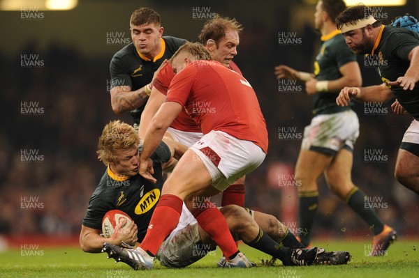 241118 - Wales v South Africa - Under Armour Series -  Pieter-Steph du Toit of South Africa is tackled by Alun Wyn Jones of Wales and Tomas Francis of Wales 