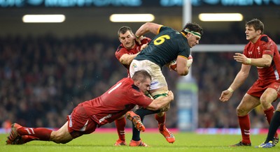 291114 - Wales v South Africa - Dove Men Series -Marcell Coetzee of South Africa is tackled by Sam Warburton and Gethin Jenkins of Wales