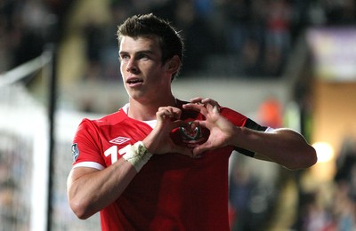 07.10.11 -  Wales v Switzerland, Euro 2012 Qualifying Match -  Wales' Gareth Bale makes a heart symbol around the Wales badges as he celebrates after scoring Wales' second goal  