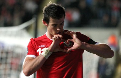 07.10.11 -  Wales v Switzerland, Euro 2012 Qualifying Match -  Wales' Gareth Bale makes a heart symbol around the Wales badges as he celebrates after scoring Wales' second goal  