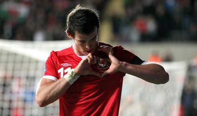 07.10.11 -  Wales v Switzerland, Euro 2012 Qualifying Match -  Wales' Gareth Bale makes a heart symbol around the Wales badges as he celebrates after scoring Wales' second goal  