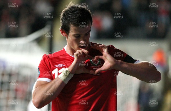 07.10.11 -  Wales v Switzerland, Euro 2012 Qualifying Match -  Wales' Gareth Bale makes a heart symbol around the Wales badges as he celebrates after scoring Wales' second goal  