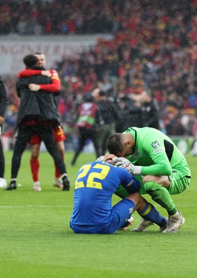 050622 -  Wales v Ukraine, World Cup Qualifying Play Off Final - Mykola Matviyenko of Ukraine in consoled by goalkeeper Georgiy Bushchan of Ukraine as Gareth Bale of Wales celebrates with Wales team mates