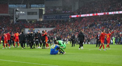 050622 -  Wales v Ukraine, World Cup Qualifying Play Off Final - Mykola Matviyenko of Ukraine in consoled by goalkeeper Georgiy Bushchan of Ukraine as Gareth Bale of Wales celebrates with Wales team mates