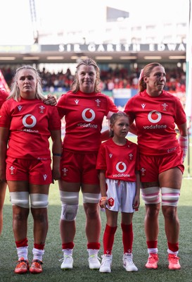 260926 Wales v USA, Vodafone Wales WXV Series - Alex Callender of Wales, Kate Williams of Wales and Georgia Evans of Wales with the match mascot during the anthems