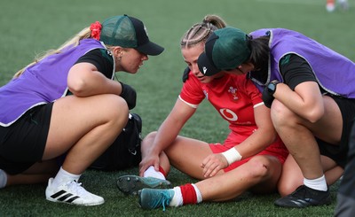 260926 Wales v USA, Vodafone Wales WXV Series - Amy Williams of Wales is checked by Erin Lynch, Wales National Squad Physio and Gwennan Williams, Team Doctor