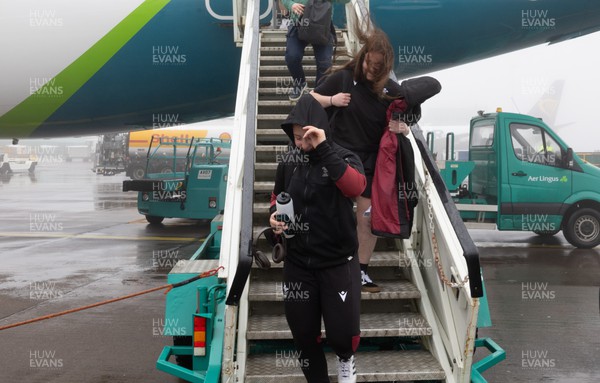110424 - Wales Women Rugby Travel to Ireland - Molly Reardon and Rosie Carr disembark the plane at a wet and windy Cork airport ahead of Wales’ Women’s 6 Nations match against Ireland