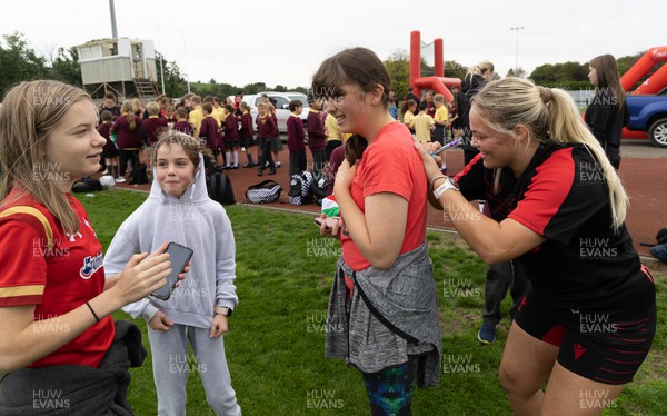 130922 - Wales Women Captains Run - Kelsey Jones of Wales signs autographs for schoolchildren after they watched the Wales Women’s Captains Run ahead of the Women’s World Cup warm up match against England