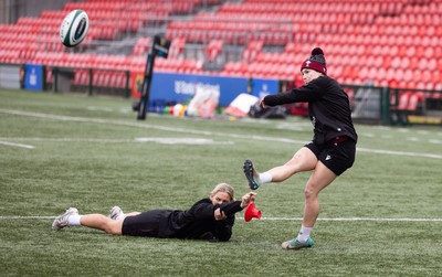 120424 - Wales Women Rugby Walkthrough - Kerin Lake steadies the ball for Keira Bevan during the kickers session at Virgin Media Park, Cork, ahead of Wales’ Women’s 6 Nations match against Ireland