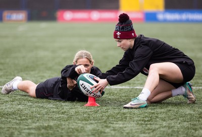 120424 - Wales Women Rugby Walkthrough - Kerin Lake steadies the ball for Keira Bevan during the kickers session at Virgin Media Park, Cork, ahead of Wales’ Women’s 6 Nations match against Ireland