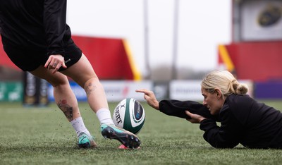 120424 - Wales Women Rugby Walkthrough - Kerin Lake steadies the ball for Keira Bevan during the kickers session at Virgin Media Park, Cork, ahead of Wales’ Women’s 6 Nations match against Ireland