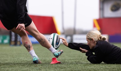 120424 - Wales Women Rugby Walkthrough - Kerin Lake steadies the ball for Keira Bevan during the kickers session at Virgin Media Park, Cork, ahead of Wales’ Women’s 6 Nations match against Ireland