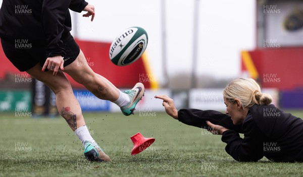 120424 - Wales Women Rugby Walkthrough - Kerin Lake steadies the ball for Keira Bevan during the kickers session at Virgin Media Park, Cork, ahead of Wales’ Women’s 6 Nations match against Ireland