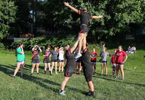 250822 - Wales Women Rugby Community Engagement in Canada - Wales’ Alisha Butchers, Gwen Crabb, and Carys Phillips, demonstrate a line out lift while working with Halifax RFC Junior Girls during a training session in Halifax, Canada