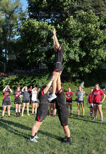 250822 - Wales Women Rugby Community Engagement in Canada - Wales’ Alisha Butchers, Gwen Crabb, and Carys Phillips, demonstrate a line out lift while working with Halifax RFC Junior Girls during a training session in Halifax, Canada