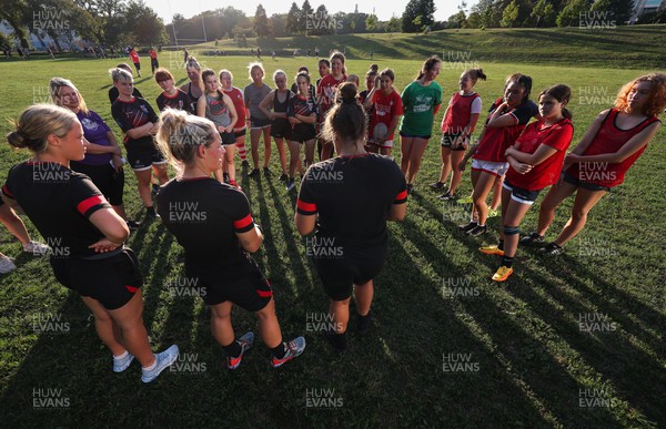 250822 - Wales Women Rugby Community Engagement in Canada - Wales’ Alisha Butchers, Kerin Lake and Carys Phillips chat with Halifax RFC Junior Girls during a training session in Halifax, Canada