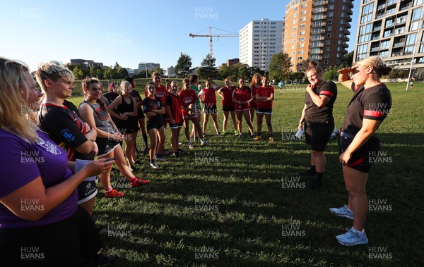 250822 - Wales Women Rugby Community Engagement in Canada - Wales’ Carys Phillips and Alisha Butchers chat with Halifax RFC Junior Girls during a training session in Halifax, Canada