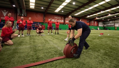 040526 - Wales Women Rugby with South Wales Fire Service - Wales International Squad member and South Wales Fire Service fire fighter Jenni Scoble brings her colleagues from Blue Watch Roath to meet and take part in team building with her Wales team members Jenna De Vera is watched by her team mates