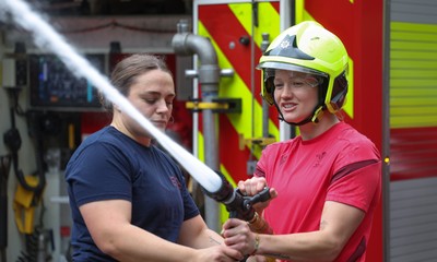 040526 - Wales Women Rugby with South Wales Fire Service - Wales International Squad member and South Wales Fire Service fire fighter Jenni Scoble brings her colleagues from Blue Watch Roath to meet and take part in team building with her Wales team members Jenni Scoble explains the hose operation to Carys Cox