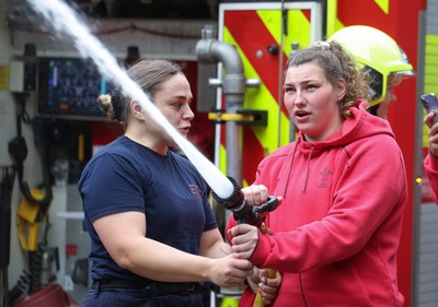 040526 - Wales Women Rugby with South Wales Fire Service - Wales International Squad member and South Wales Fire Service fire fighter Jenni Scoble brings her colleagues from Blue Watch Roath to meet and take part in team building with her Wales team members Jenni Scoble explains the hose operation to Gwenllian Pyrs