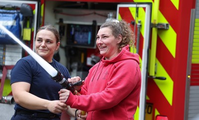 040526 - Wales Women Rugby with South Wales Fire Service - Wales International Squad member and South Wales Fire Service fire fighter Jenni Scoble brings her colleagues from Blue Watch Roath to meet and take part in team building with her Wales team members Jenni Scoble explains the hose operation to Gwenllian Pyrs