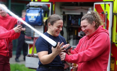 040526 - Wales Women Rugby with South Wales Fire Service - Wales International Squad member and South Wales Fire Service fire fighter Jenni Scoble brings her colleagues from Blue Watch Roath to meet and take part in team building with her Wales team members Jenni Scoble explains the hose operation to Gwenllian Pyrs