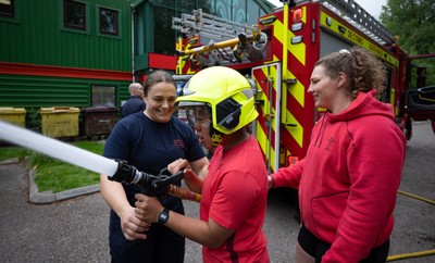 040526 - Wales Women Rugby with South Wales Fire Service - Wales International Squad member and South Wales Fire Service fire fighter Jenni Scoble brings her colleagues from Blue Watch Roath to meet and take part in team building with her Wales team members Jenni Scoble explains the hose operation to Jenna De Vera