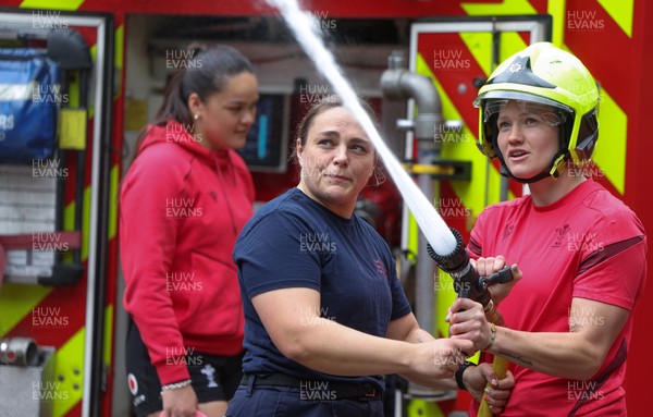 040526 - Wales Women Rugby with South Wales Fire Service - Wales International Squad member and South Wales Fire Service fire fighter Jenni Scoble brings her colleagues from Blue Watch Roath to meet and take part in team building with her Wales team members Jenni Scoble explains the hose operation to Carys Cox