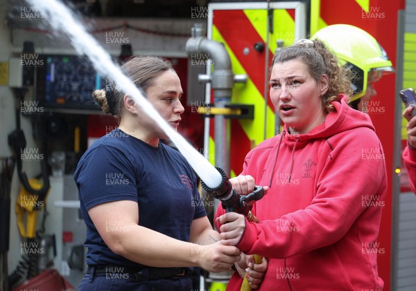 040526 - Wales Women Rugby with South Wales Fire Service - Wales International Squad member and South Wales Fire Service fire fighter Jenni Scoble brings her colleagues from Blue Watch Roath to meet and take part in team building with her Wales team members Jenni Scoble explains the hose operation to Gwenllian Pyrs