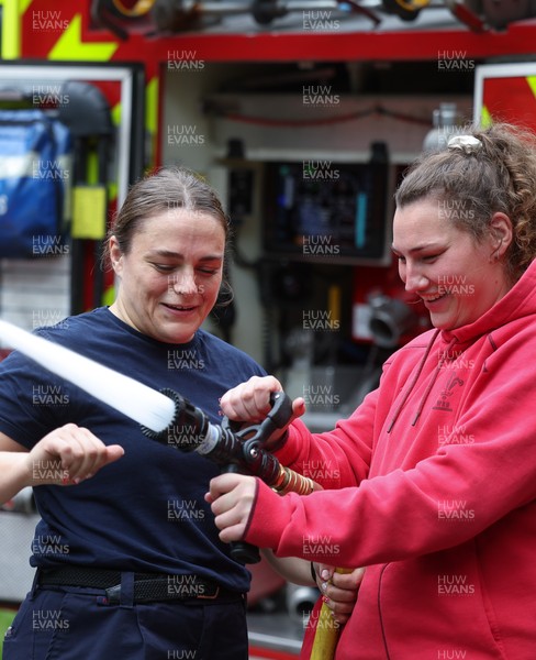 040526 - Wales Women Rugby with South Wales Fire Service - Wales International Squad member and South Wales Fire Service fire fighter Jenni Scoble brings her colleagues from Blue Watch Roath to meet and take part in team building with her Wales team members Jenni Scoble explains the hose operation to Gwenllian Pyrs