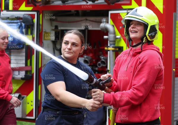 040526 - Wales Women Rugby with South Wales Fire Service - Wales International Squad member and South Wales Fire Service fire fighter Jenni Scoble brings her colleagues from Blue Watch Roath to meet and take part in team building with her Wales team members Jenni Scoble explains the hose operation to Tilly Vucaj