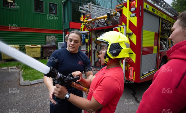 040526 - Wales Women Rugby with South Wales Fire Service - Wales International Squad member and South Wales Fire Service fire fighter Jenni Scoble brings her colleagues from Blue Watch Roath to meet and take part in team building with her Wales team members Jenni Scoble explains the hose operation to Jenna De Vera