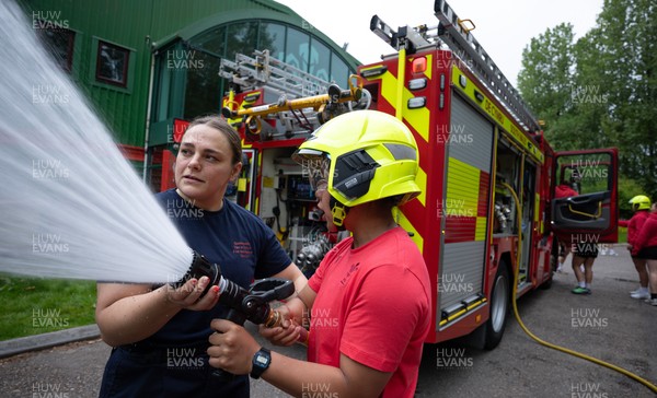 040526 - Wales Women Rugby with South Wales Fire Service - Wales International Squad member and South Wales Fire Service fire fighter Jenni Scoble brings her colleagues from Blue Watch Roath to meet and take part in team building with her Wales team members Jenni Scoble explains the hose operation to Jenna De Vera