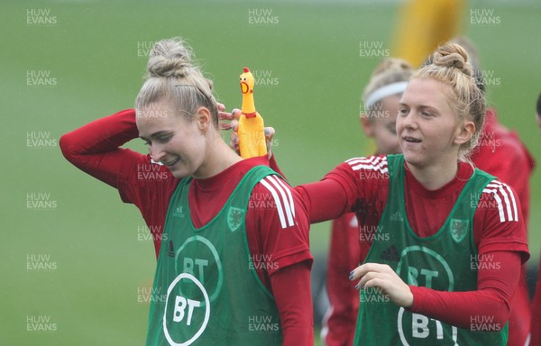 191021 - Wales Women Football Training - Rhiannon Roberts and Ceri Holland enjoy a joke with a rubber chicken used during a warm up game during a Wales Women training session ahead of the World Cup Qualifying matches against Slovenia and Estonia