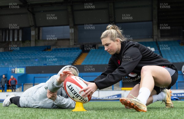 140423 - Wales Women Rugby Kickers Practice - Keira Bevan, with assistance from Kelsey Jones, during kickers practice at Cardiff Arms Park ahead of the TicTok Women’s 6 Nations match against England tomorrow