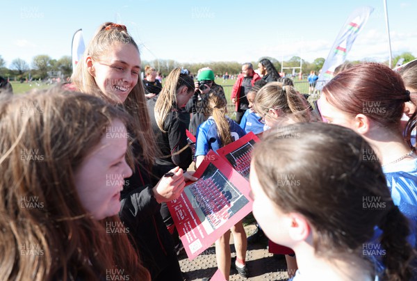 190424 - Wales Women Rugby Media session - Wales captain Hannah Jones signs autographs and poses for photographs with players involved in the Urdd WRU 7s during a media session held at the event ahead of Wales’ Guinness 6 Nations match against France