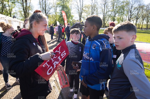 190424 - Wales Women Rugby Media session - Wales captain Hannah Jones signs autographs and poses for photographs with players involved in the Urdd WRU 7s during a media session held at the event ahead of Wales’ Guinness 6 Nations match against France