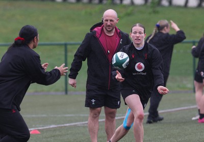 100424 - Wales Women Rugby Training - Mike Hill, Wales Women forwards coach, looks on as Carys Cox passes during a training session ahead of Wales’ Women’s 6 Nations match against Ireland