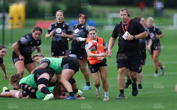 140923 - Wales Women Rugby Training Session - Keira Bevan feeds the ball out watched by Ioan Cunningham during training session