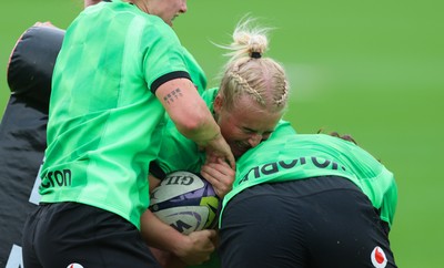 140926 Wales Women Rugby Training Session - Seren Singleton is tackled during a rugby training session ahead of the WXV matches against South Africa and USA