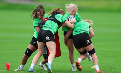 140926 Wales Women Rugby Training Session - Seren Lockwood is tackled during a rugby training session ahead of the WXV matches against South Africa and USA