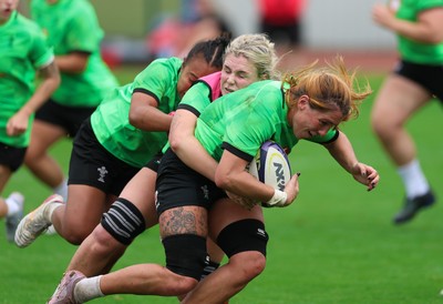 140926 Wales Women Rugby Training Session - Georgia Evans is tackled by Alex Callender and Jenna De Vera during a rugby training session ahead of the WXV matches against South Africa and USA