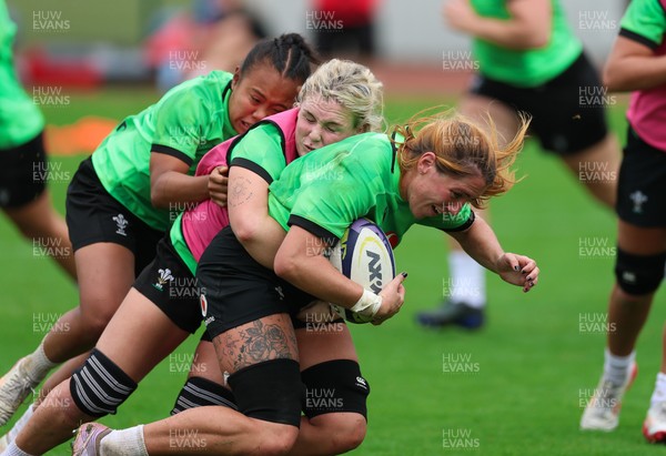 140926 Wales Women Rugby Training Session - Georgia Evans is tackled by Alex Callender and Jenna De Vera during a rugby training session ahead of the WXV matches against South Africa and USA