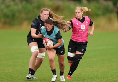 150725 - Wales Women Rugby training - Kayleigh Powell gets past Alaw Pyrs during a training session ahead of their two match tour against Australia