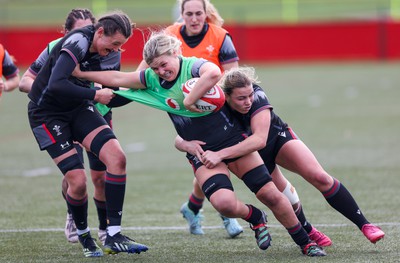 210323 - Wales Women Rugby Training Session - Alex Callender takes on Charlie Munday and Amelia Tutt during a training session ahead of Wales’ opening Women’s 6 Nations match against Ireland